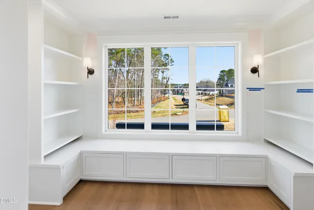 an empty room with windows and fan