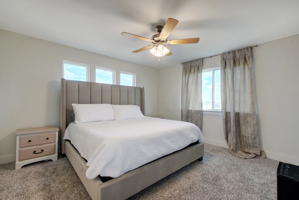 413 White Steppe Way Georgetown, TX 78626 - Photo 12 of 25 a large bed sitting in a bedroom next to a window and a chandelier