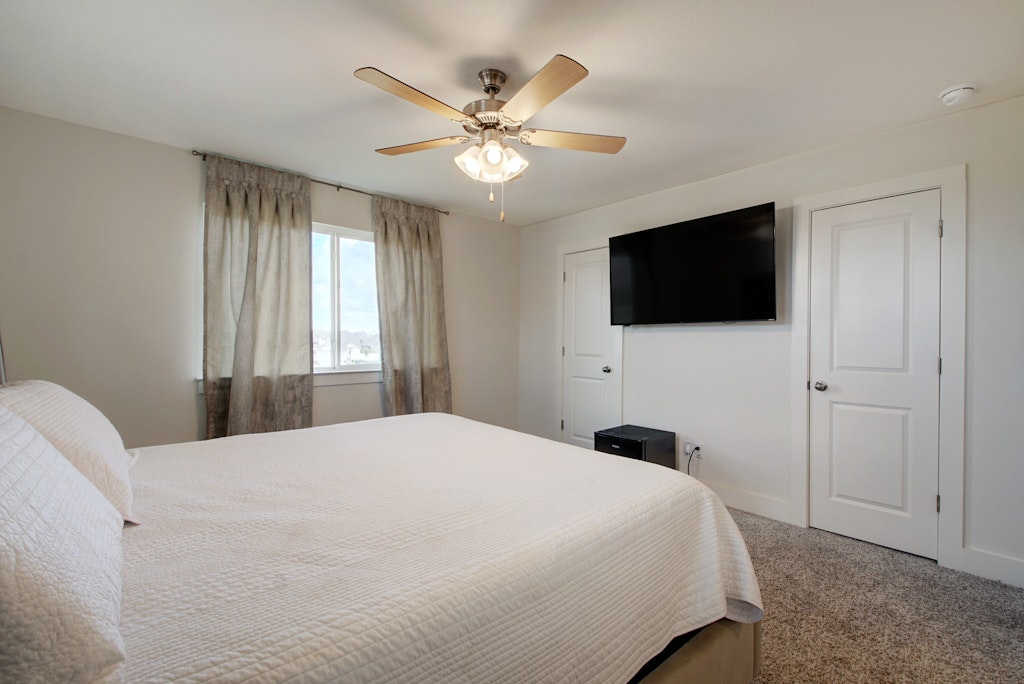 413 White Steppe Way Georgetown, TX 78626 - Photo 13 of 25 a bedroom with a large bed and a flat tv screen on dresser