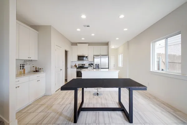 a kitchen with stainless steel appliances kitchen island hardwood floor sink stove refrigerator and wooden floor