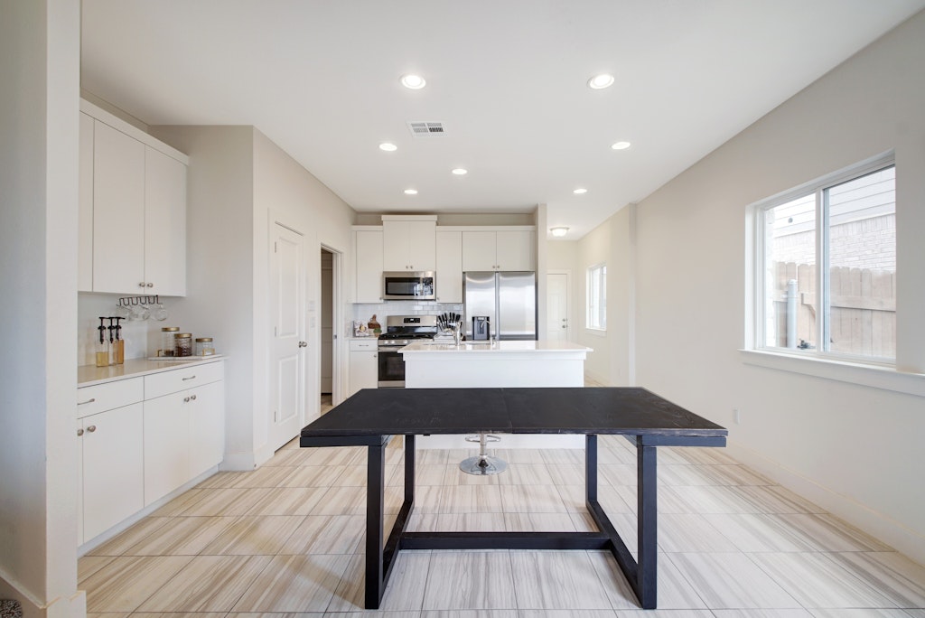 413 White Steppe Way Georgetown, TX 78626 - Photo 7 of 25 a kitchen with stainless steel appliances kitchen island hardwood floor sink stove refrigerator and wooden floor