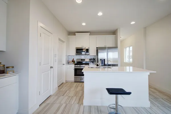a kitchen with kitchen island white cabinets and stainless steel appliances