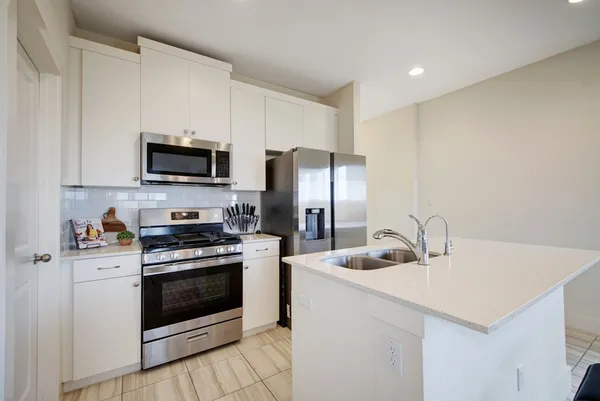 a kitchen with appliances a sink cabinets and a counter top space