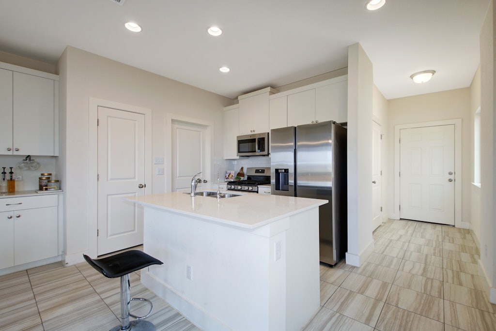 413 White Steppe Way Georgetown, TX 78626 - Photo 10 of 25 a kitchen with stainless steel appliances a refrigerator and a stove top oven