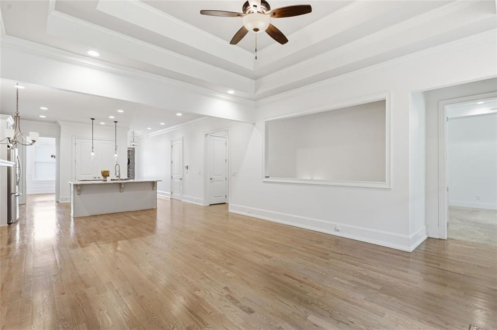 337 Rosshandler Road Suwanee, GA 30024 - Photo 18 of 45 a view of an empty room and kitchen view with wooden floor and a ceiling fan
