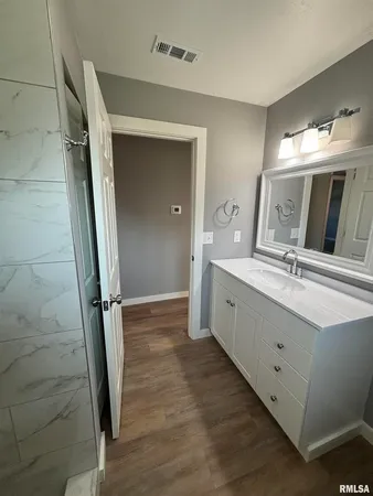 a spacious bathroom with a double vanity sink and a mirror