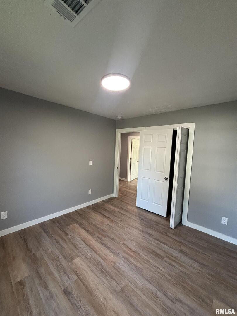 710 Catherine Street Metropolis, IL 62960 - Photo 15 of 18 an empty room with wooden floor and windows