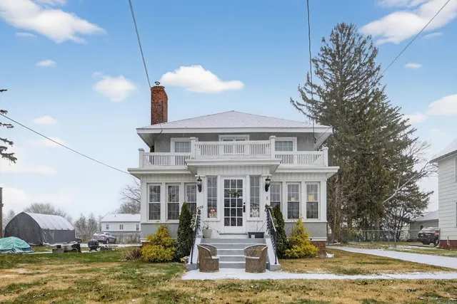 a front view of a house with a yard swimming pool and outdoor seating