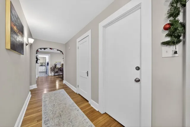 a view of hallway with wooden floor and cabinet