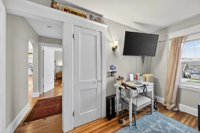 a large bedroom with a bed and flat tv screen on the dresser