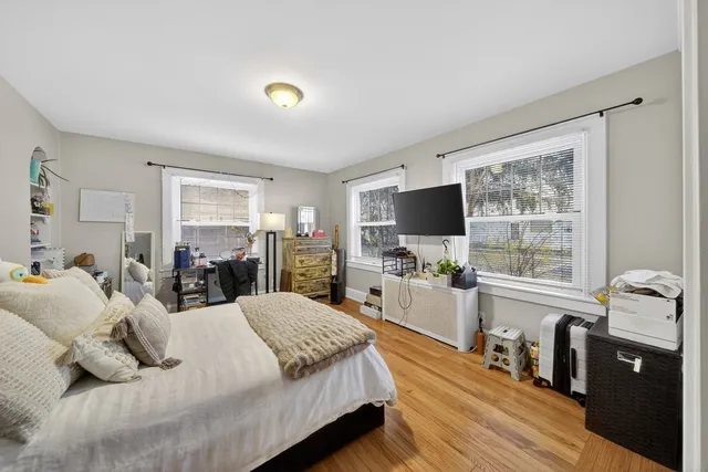 a bedroom with a bed and painting on the wall
