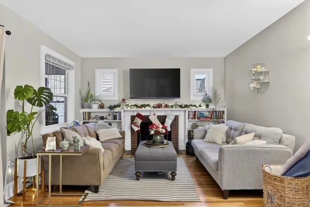 a view of a hallway with wooden floor and a potted plant