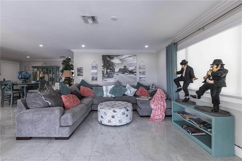 164 Trinidad Street Naples, FL 34113 - Photo 22 of 43 a living room with furniture a table and a painting