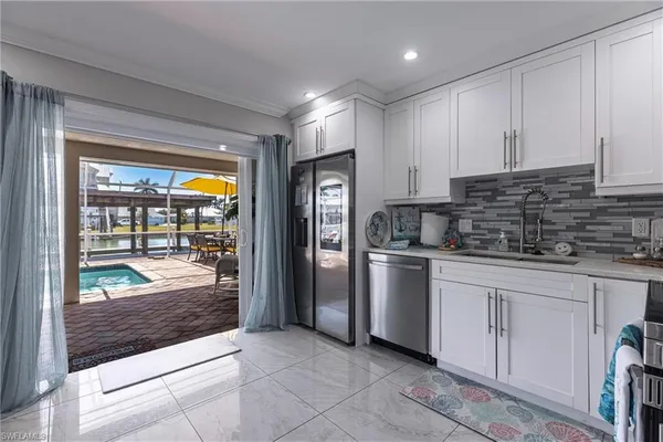 a kitchen with a refrigerator and a stove top oven
