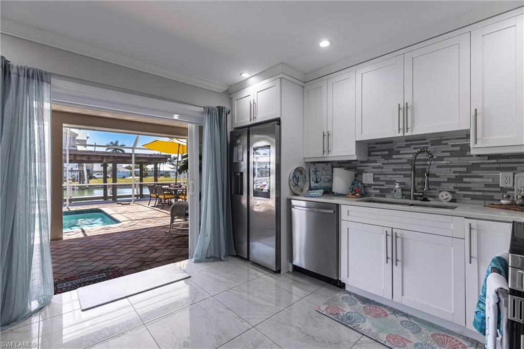 164 Trinidad Street Naples, FL 34113 - Photo 25 of 43 a kitchen with stainless steel appliances granite countertop a refrigerator and a sink