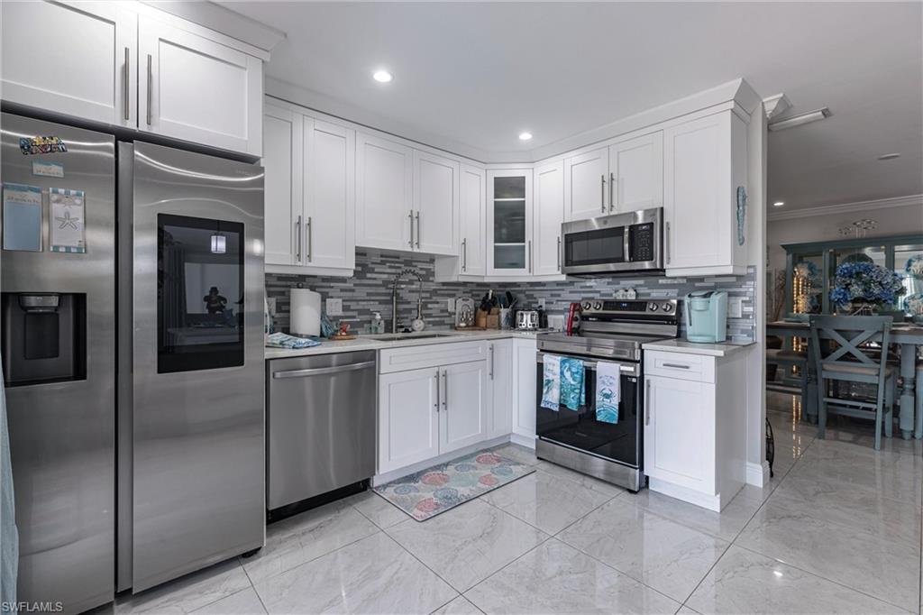 164 Trinidad Street Naples, FL 34113 - Photo 26 of 43 a kitchen with a refrigerator and a stove top oven