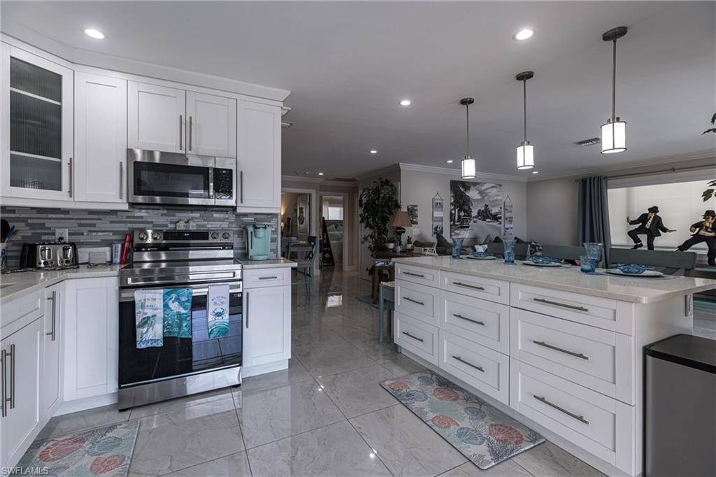 164 Trinidad Street Naples, FL 34113 - Photo 28 of 43 a kitchen with stainless steel appliances granite countertop a stove and cabinets