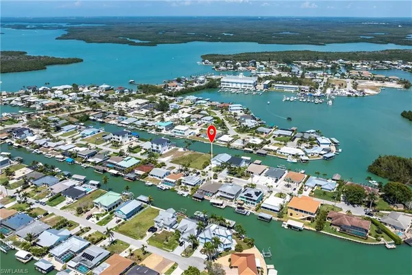 an aerial view of water body with boats and residential houses with outdoor space