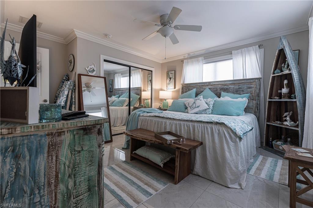 164 Trinidad Street Naples, FL 34113 - Photo 33 of 43 a bedroom with a bed a flat screen tv and windows