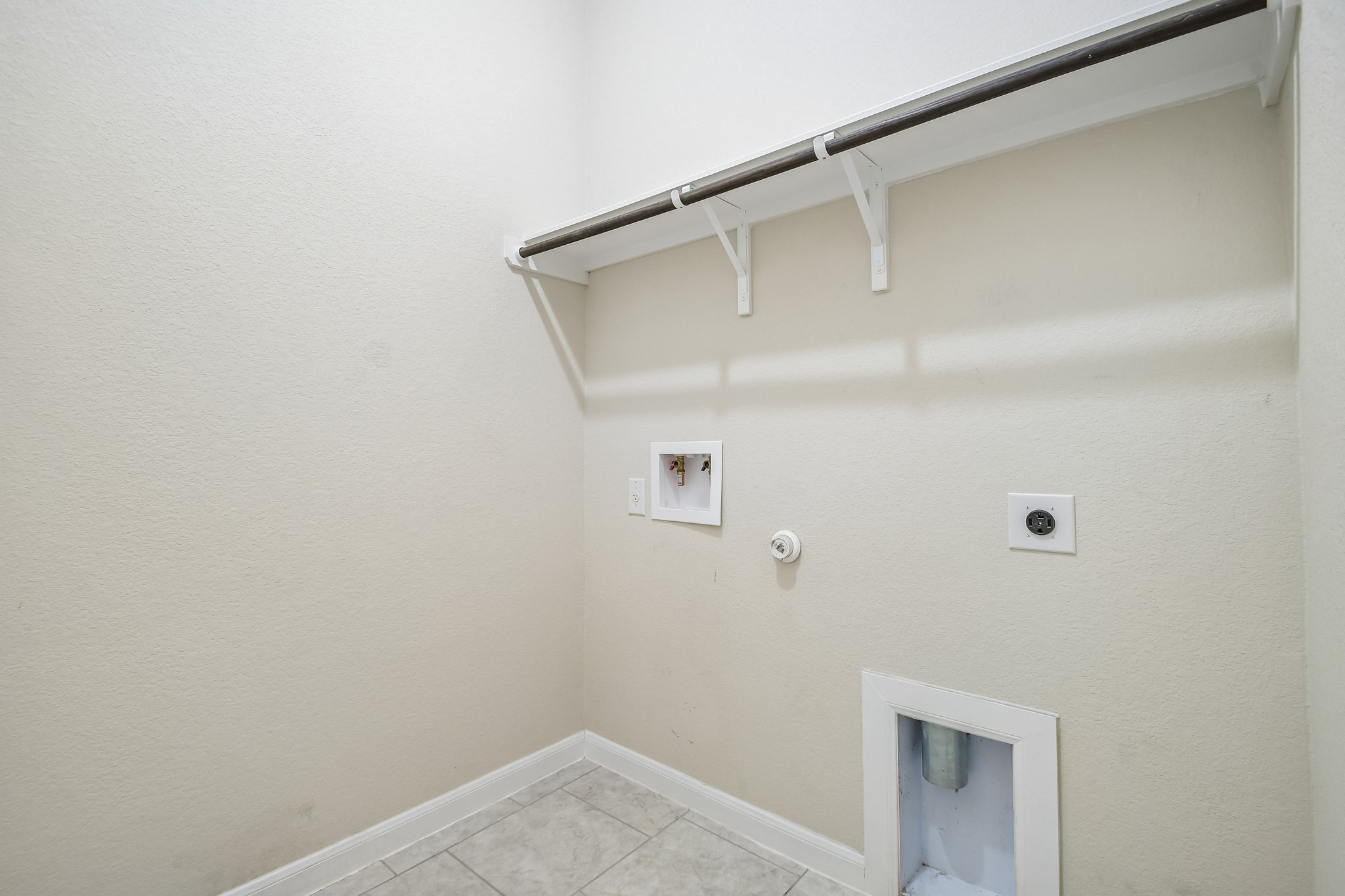 280 Rimrock Court Bastrop, TX 78602 - Photo 26 of 34 A dedicated laundry space features tile flooring and a built-in storage shelf.