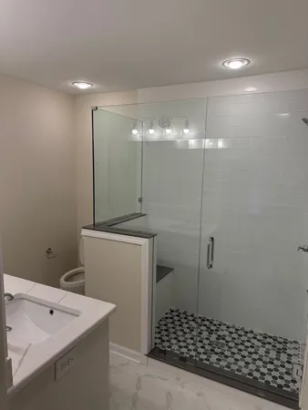 a bathroom with a shower a toilet and a sink