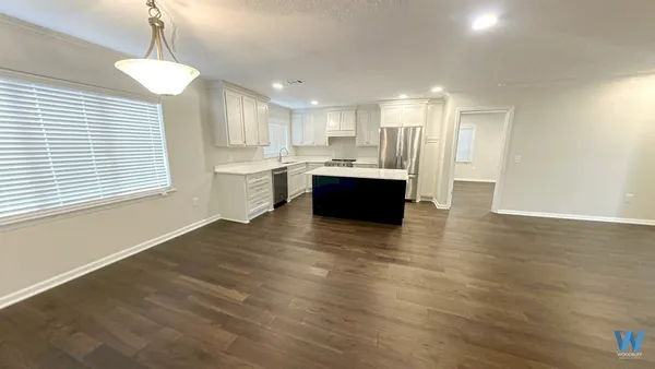a large kitchen with kitchen island a sink wooden floor and a chandelier