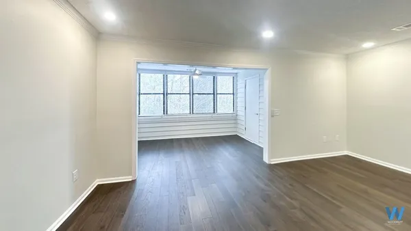 a view of a room with wooden floor and window