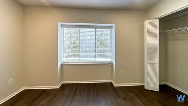 an empty room with wooden floor and a window