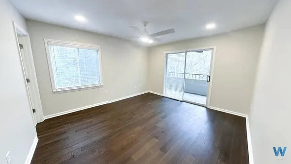 an empty room with wooden floor and windows
