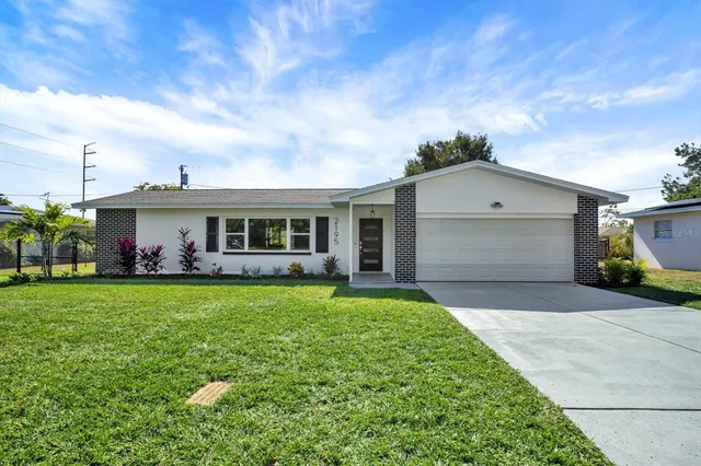a front view of a house with a garden