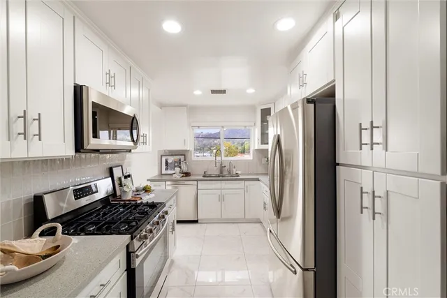 a kitchen with stainless steel appliances granite countertop a refrigerator stove and sink
