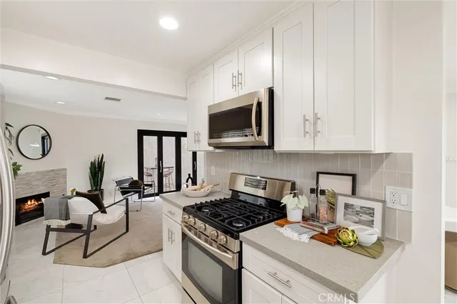 a living room with furniture a flat screen tv and a stove