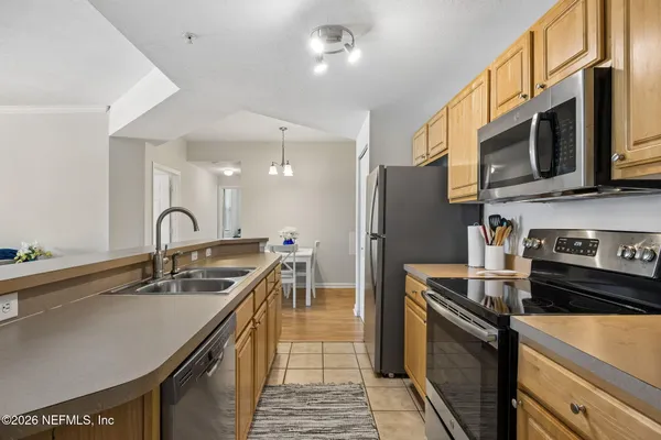 a kitchen with stainless steel appliances granite countertop a sink a stove and a refrigerator