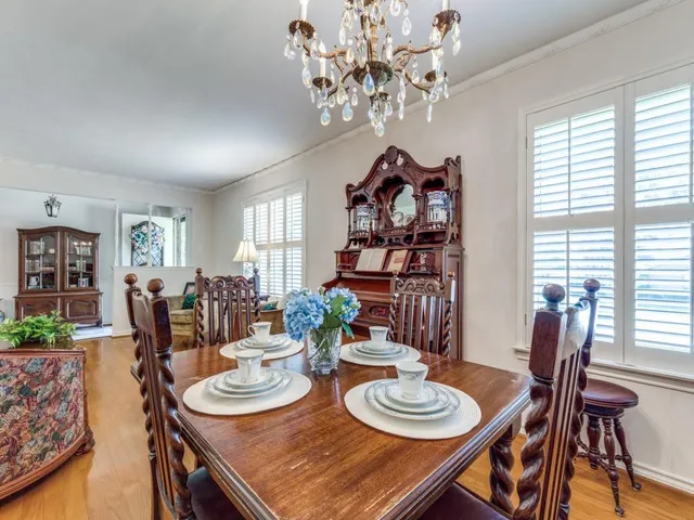 a view of a dining room with furniture a chandelier and wooden floor