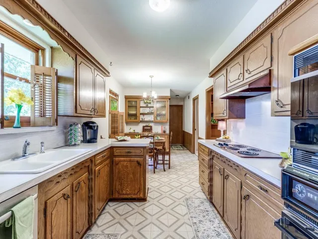a kitchen with stainless steel appliances granite countertop sink stove top oven and cabinets