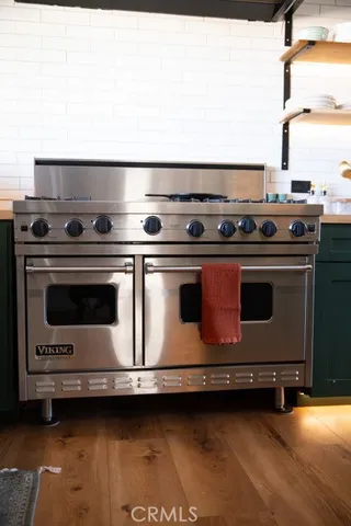 a kitchen with stainless steel appliances granite countertop a sink a stove a dining table and chairs