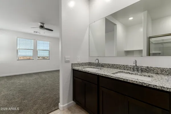 a bathroom with a granite countertop sink a large mirror and a window