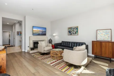 a living room with furniture a flat screen tv and a fireplace