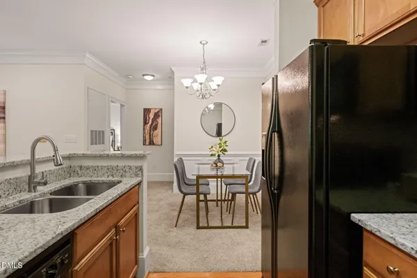 a kitchen with stainless steel appliances granite countertop a sink a refrigerator and a stove