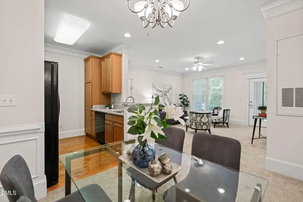a living room with furniture kitchen view and a chandelier