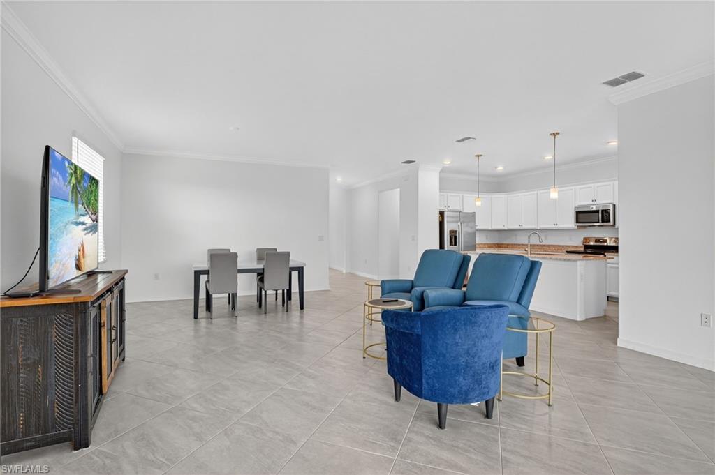 2126 Hamlin Street Naples, FL 34120 - Photo 5 of 34 a living room with furniture a dining table and a kitchen view