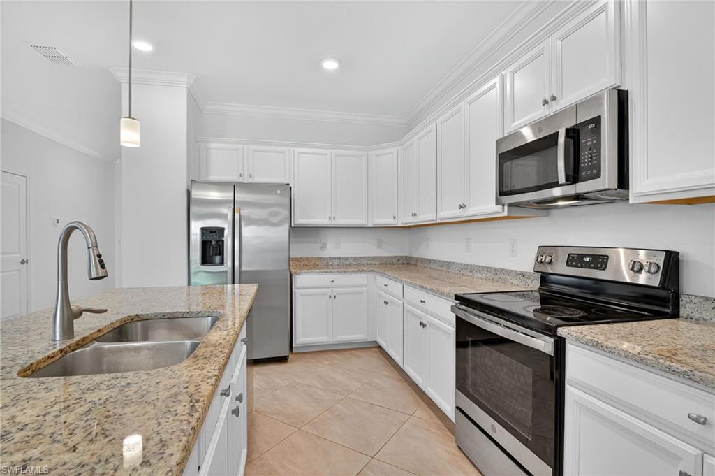 2126 Hamlin Street Naples, FL 34120 - Photo 8 of 34 a kitchen with stainless steel appliances granite countertop a sink and a stove