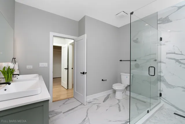 a bathroom with a granite countertop sink a toilet and shower