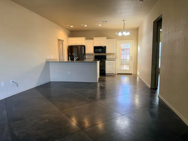 a view of kitchen with stainless steel appliances granite countertop a stove a sink and a refrigerator
