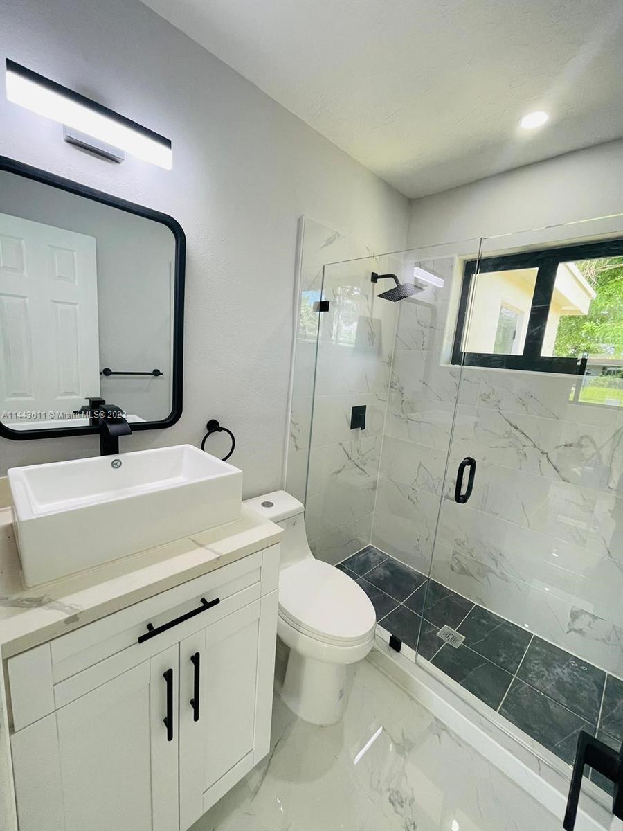 2521 Northwest 121st Street Miami, FL 33167 - Photo 17 of 43 a bathroom with a sink a toilet and shower
