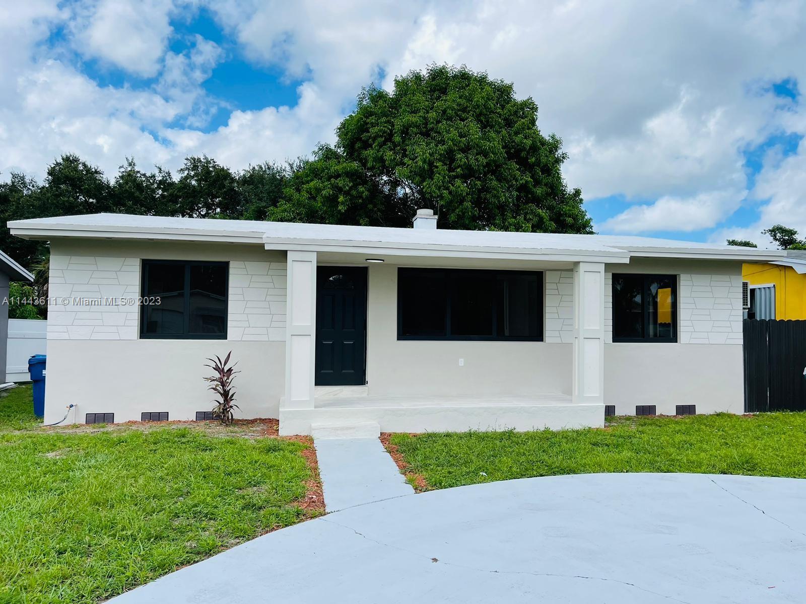 2521 Northwest 121st Street Miami, FL 33167 - Photo 2 of 43 a front view of a house with a garden and yard