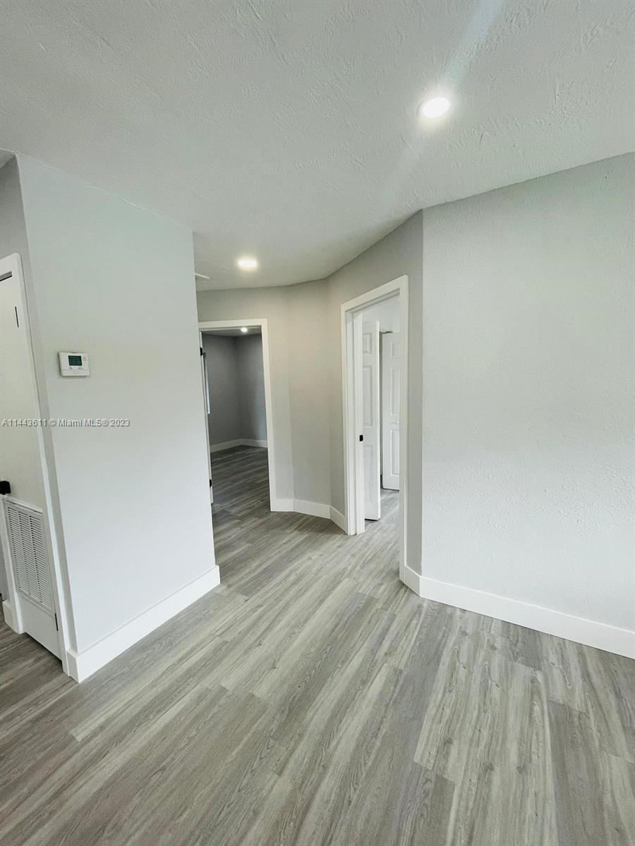 2521 Northwest 121st Street Miami, FL 33167 - Photo 23 of 43 an empty room with wooden floor and entrance
