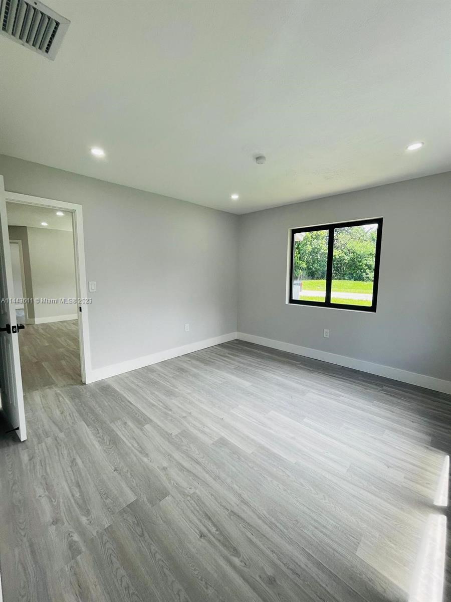 2521 Northwest 121st Street Miami, FL 33167 - Photo 24 of 43 an empty room with wooden floor and windows