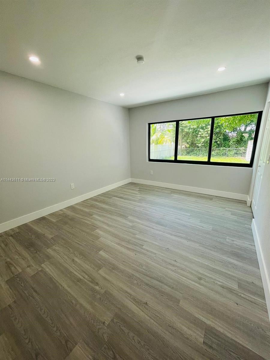 2521 Northwest 121st Street Miami, FL 33167 - Photo 30 of 43 an empty room with wooden floor and windows