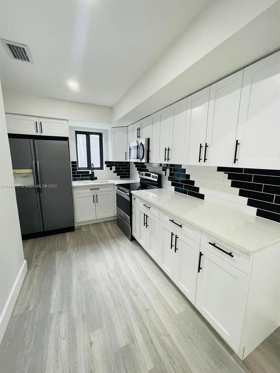 2521 Northwest 121st Street Miami, FL 33167 - Photo 4 of 43 a kitchen with cabinets a sink and appliances